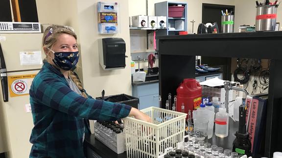 A woman in a lab wearing a face mask.