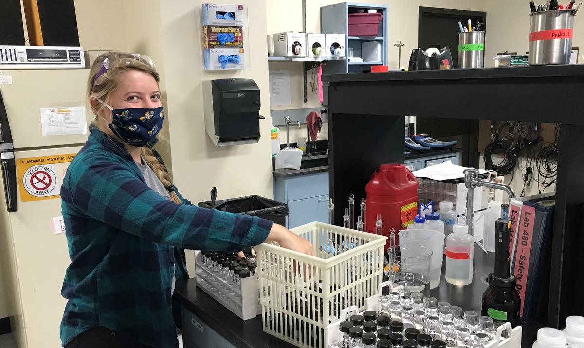 A woman in a lab wearing a face mask.