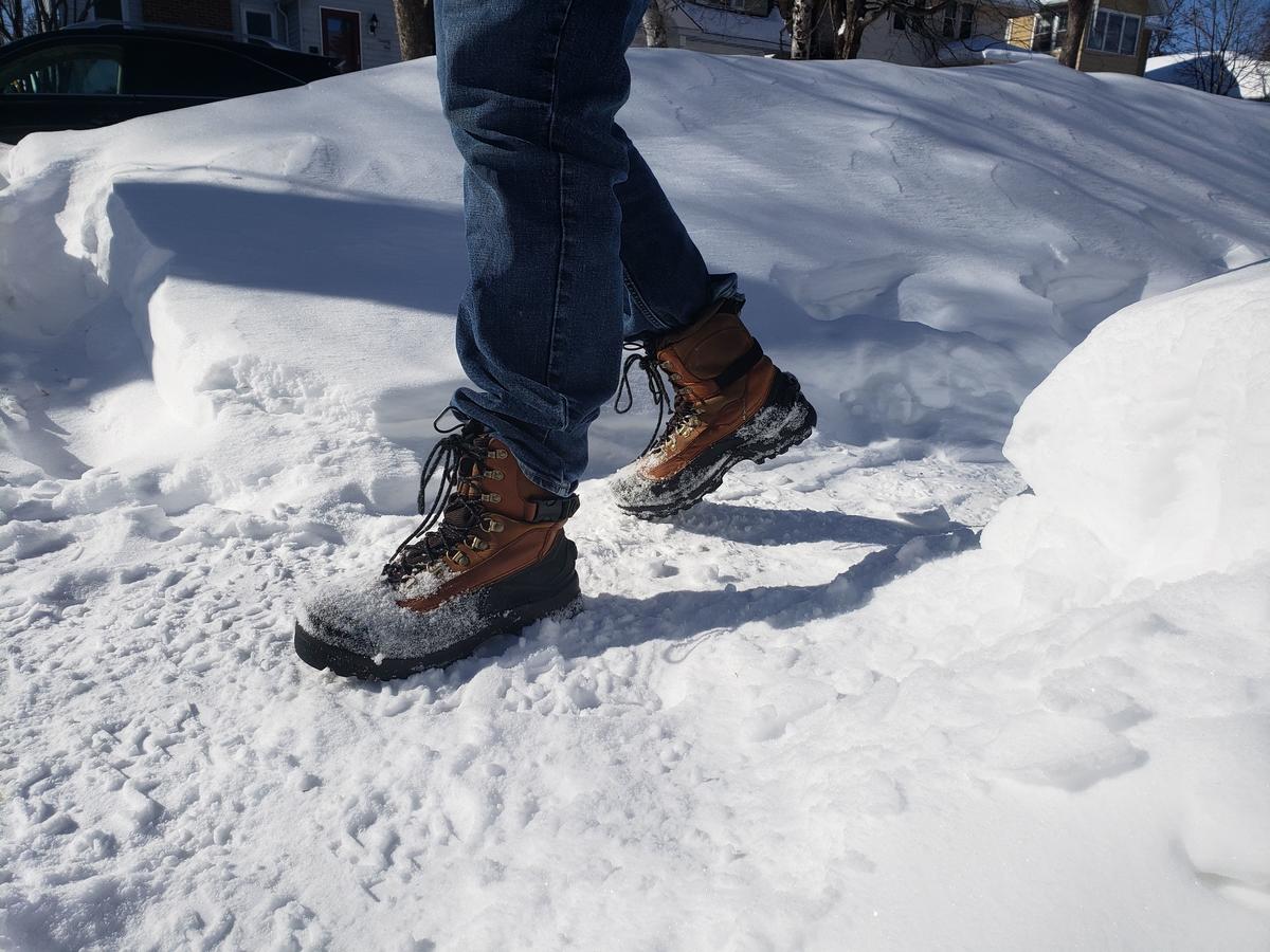 Winter boots walking on snowy sidewalk