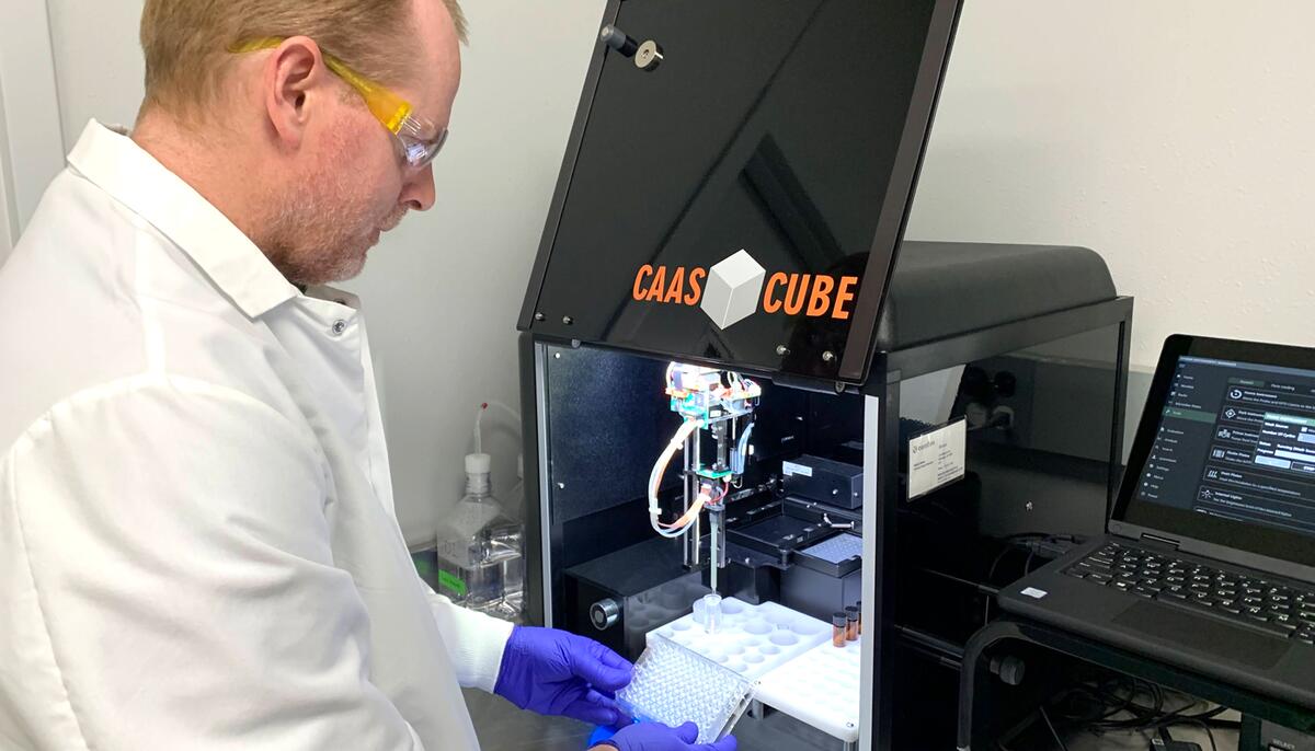 Researcher adds water samples in glass vials to a diagnostic computer.