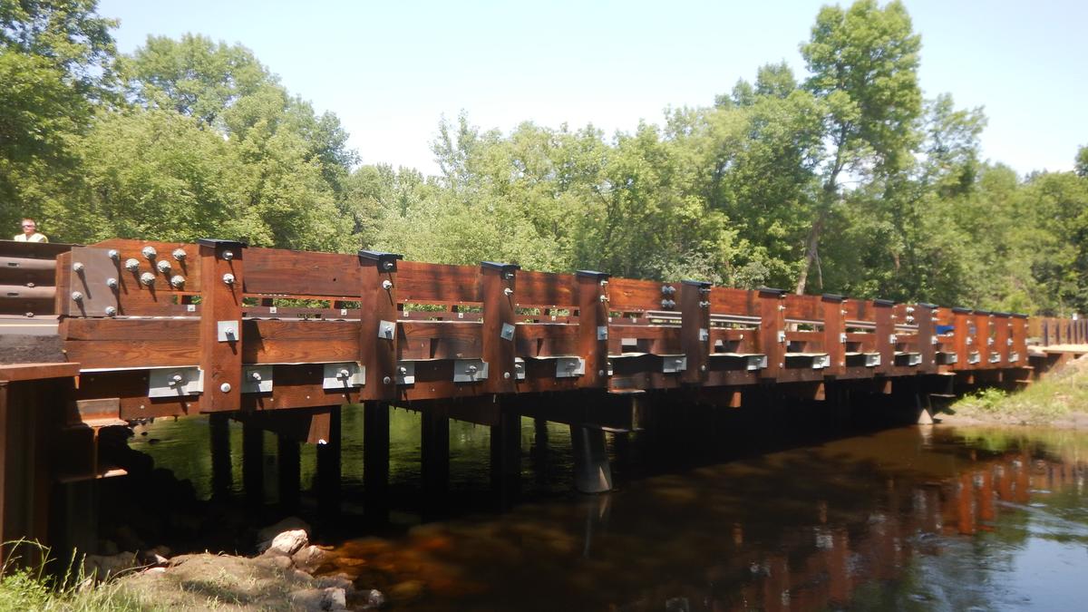 Wood bridge extends across a small river.