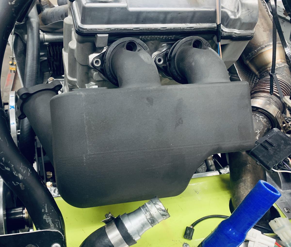 Black engine part installed on snowmobile engine