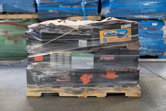 A shipping pallet holds a stack of batteries wrapped in plastic.